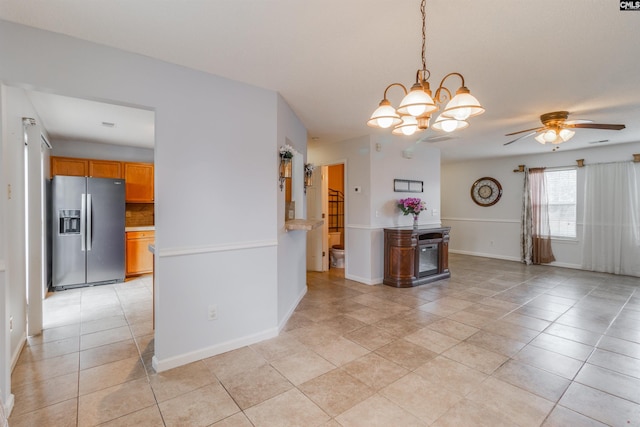 empty room featuring light tile patterned floors and ceiling fan with notable chandelier