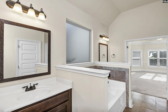 bathroom with tile patterned flooring, vanity, a bathtub, and lofted ceiling