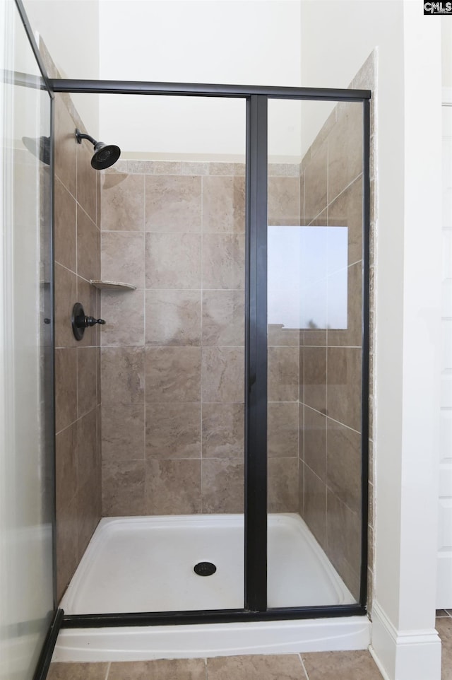 bathroom featuring tile patterned flooring and an enclosed shower