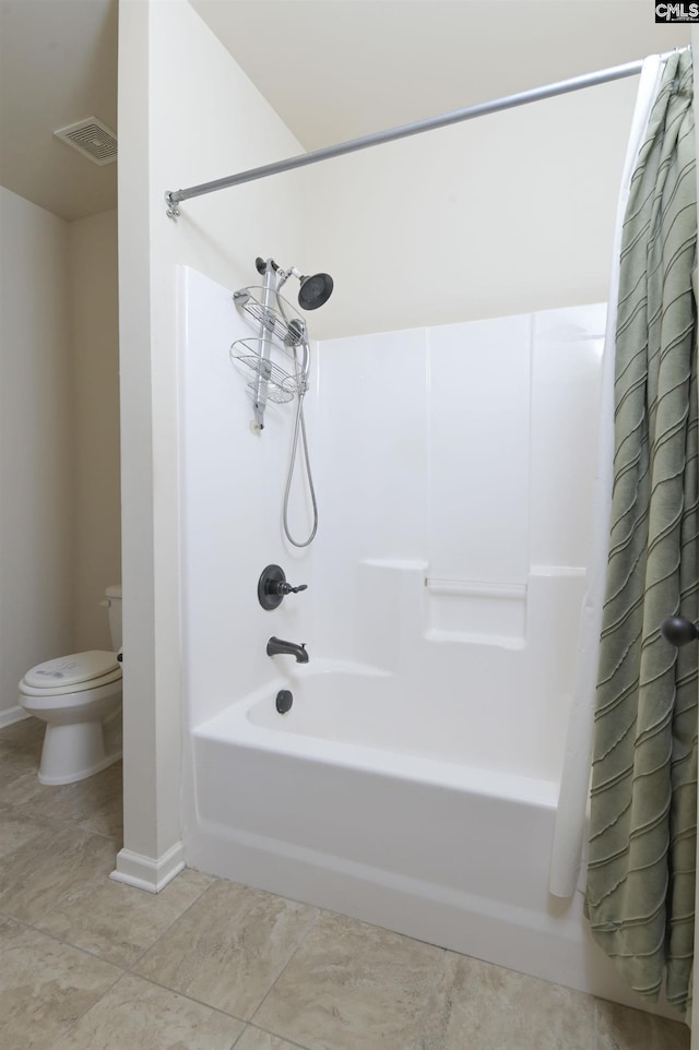 bathroom featuring tile patterned floors, toilet, and shower / bathtub combination with curtain