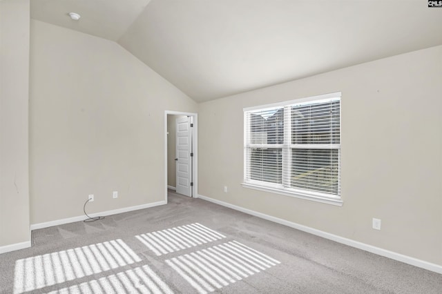 carpeted spare room with lofted ceiling