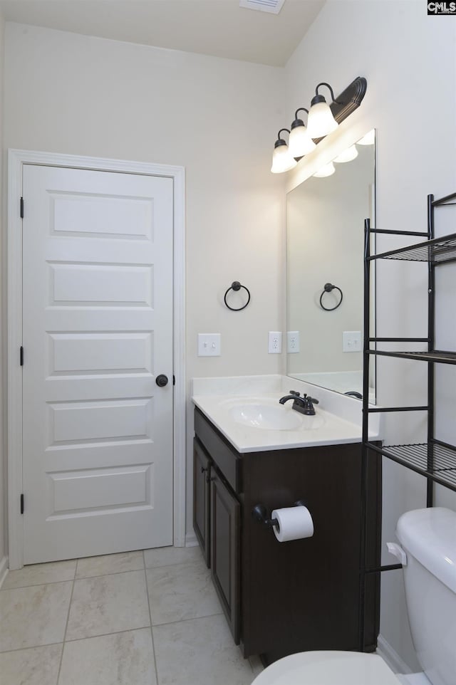 bathroom featuring tile patterned flooring, vanity, and toilet