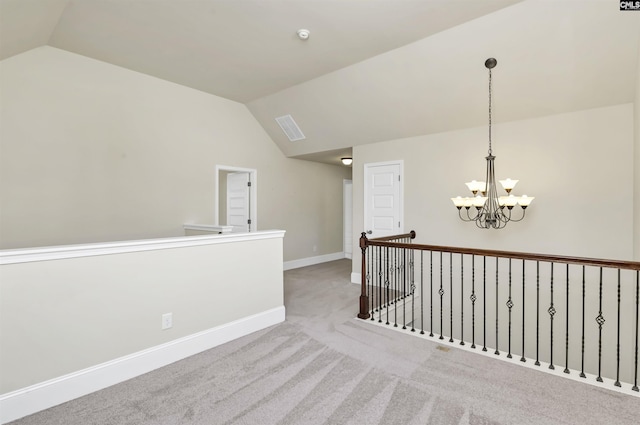 hall featuring a notable chandelier, lofted ceiling, and light carpet