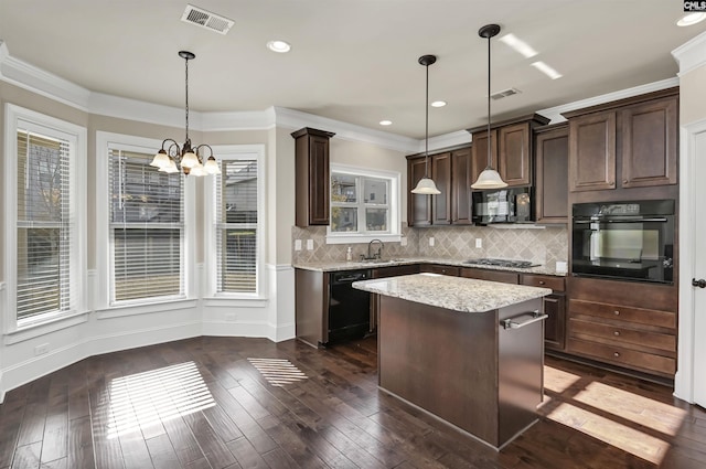 kitchen with a center island, black appliances, hanging light fixtures, a wealth of natural light, and dark hardwood / wood-style flooring