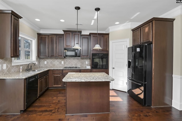 kitchen with pendant lighting, a center island, black appliances, sink, and dark hardwood / wood-style floors