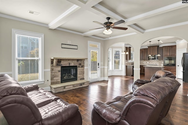 living room with a fireplace, ceiling fan, crown molding, and dark wood-type flooring