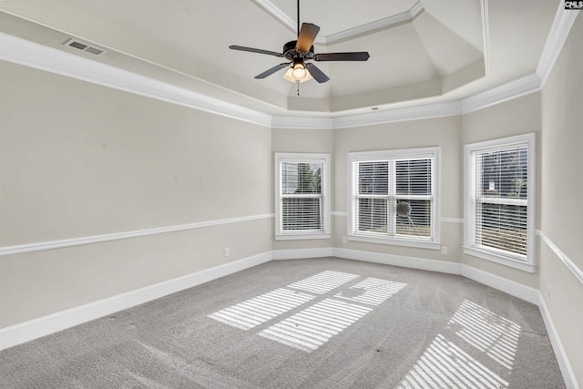 spare room with ceiling fan, a raised ceiling, light colored carpet, and crown molding