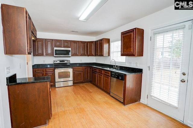 kitchen with sink, light hardwood / wood-style flooring, a healthy amount of sunlight, and appliances with stainless steel finishes