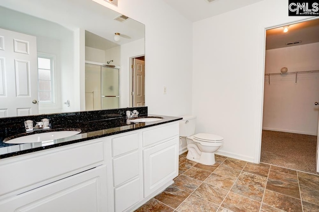 bathroom with vanity, a shower with shower door, and toilet