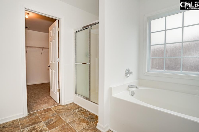 bathroom featuring shower with separate bathtub