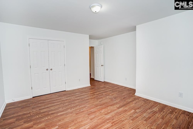 unfurnished bedroom with a closet and light hardwood / wood-style flooring