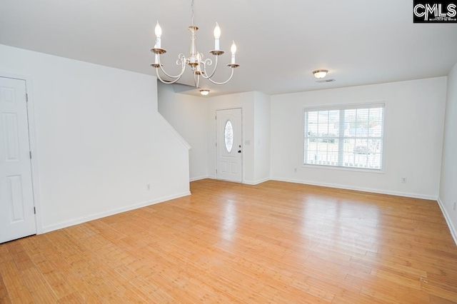 foyer with light wood-type flooring and an inviting chandelier