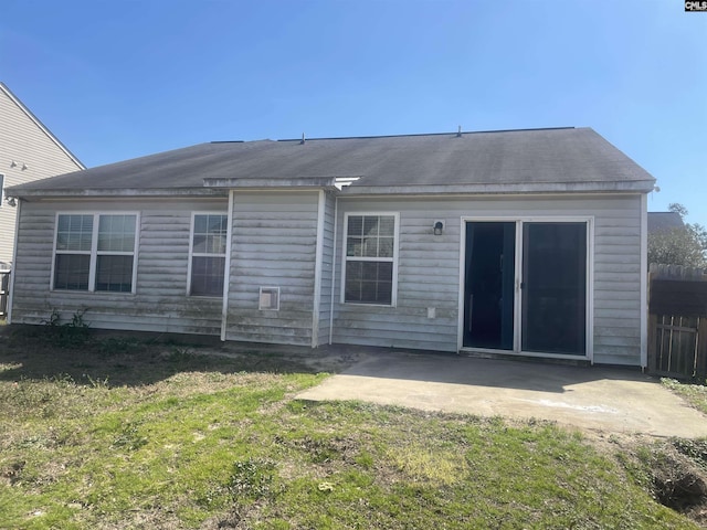 back of property featuring fence, a patio, and a yard