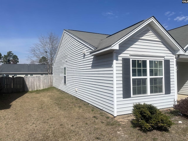 view of home's exterior featuring a yard and fence