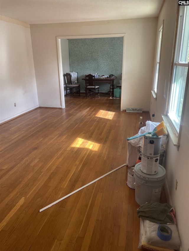 unfurnished room featuring visible vents and hardwood / wood-style flooring