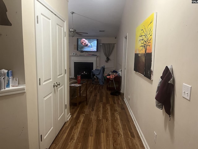 hall featuring wood finished floors, visible vents, and baseboards