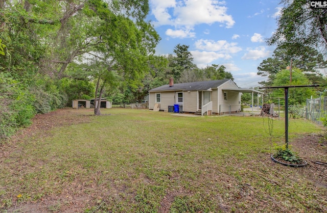 2432 Falcon Rd, North Charleston, SC 29406 - view of yard featuring a carport, entry steps, a shed, an outbuilding, and fence