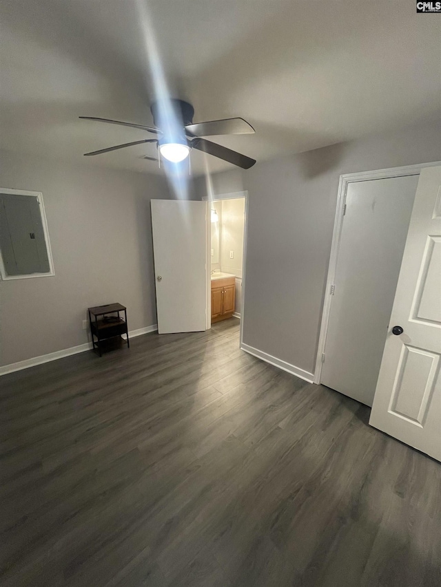 interior space with electric panel, dark hardwood / wood-style floors, and ceiling fan