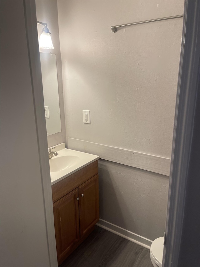 bathroom with vanity, wood-type flooring, and toilet