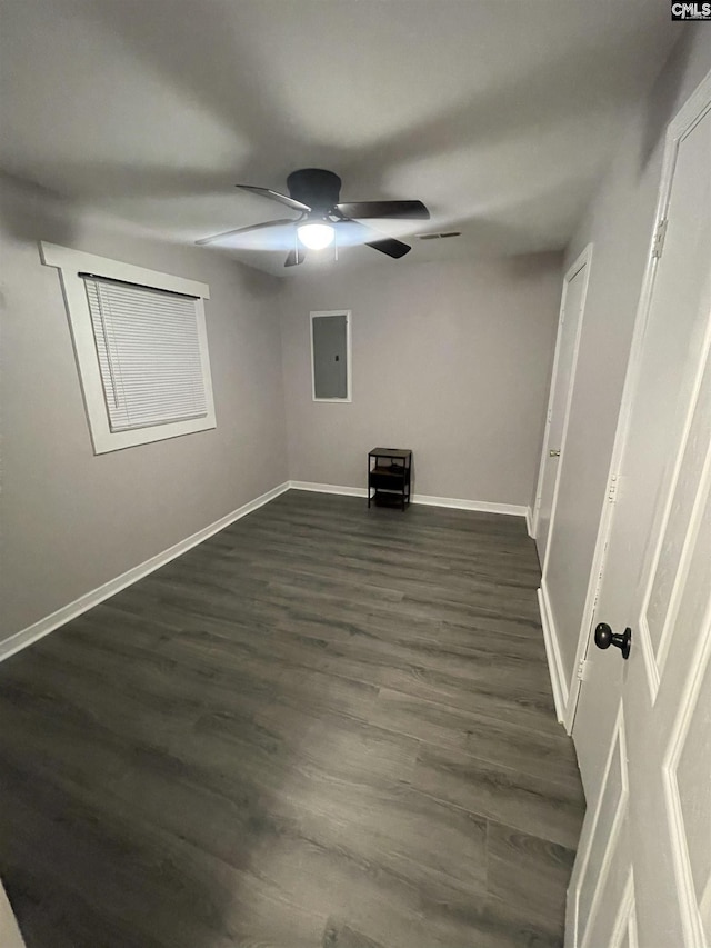 empty room featuring dark hardwood / wood-style floors, ceiling fan, and electric panel