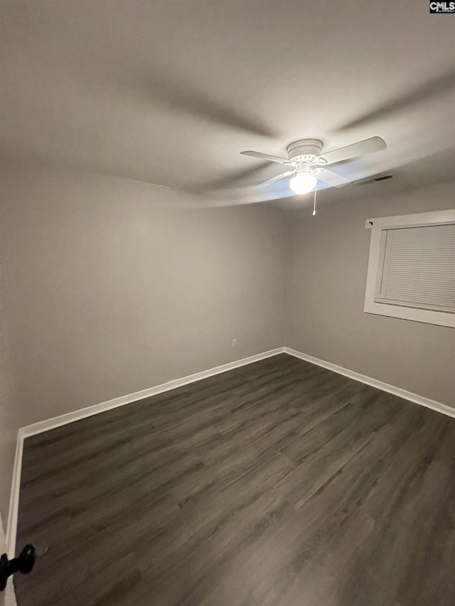 spare room with ceiling fan and dark wood-type flooring