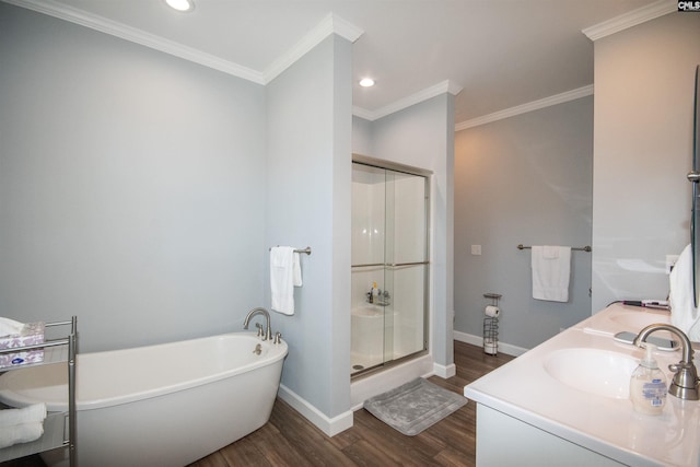 bathroom featuring wood-type flooring, vanity, separate shower and tub, and ornamental molding