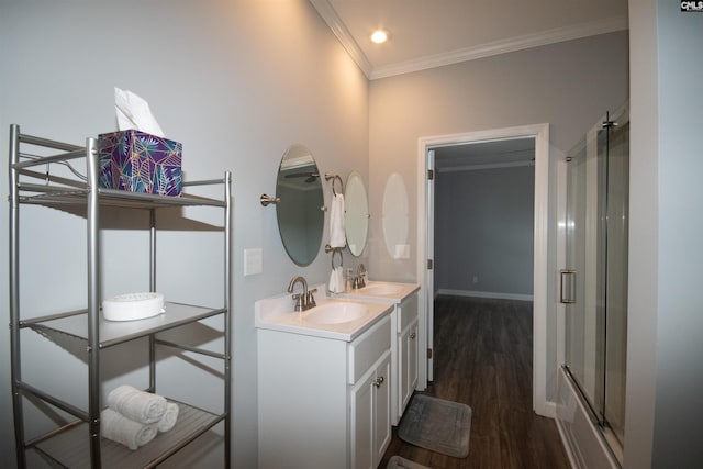 bathroom with wood-type flooring, vanity, crown molding, and enclosed tub / shower combo