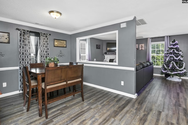 dining space with ornamental molding, a textured ceiling, and dark wood-type flooring