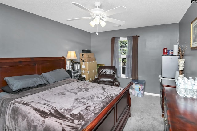 bedroom featuring a textured ceiling, light colored carpet, and ceiling fan