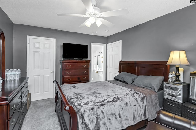 bedroom featuring light carpet, a textured ceiling, ensuite bathroom, and ceiling fan