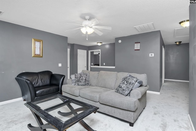 carpeted living room featuring ceiling fan and a textured ceiling