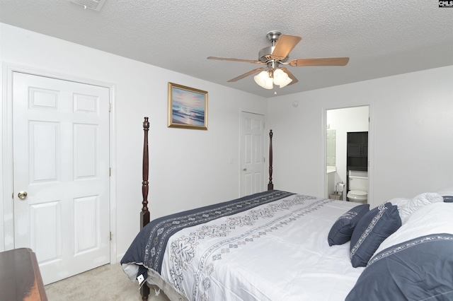 bedroom with carpet flooring, connected bathroom, ceiling fan, and a textured ceiling