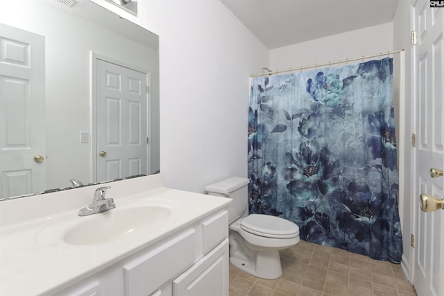 bathroom with curtained shower, vanity, and toilet