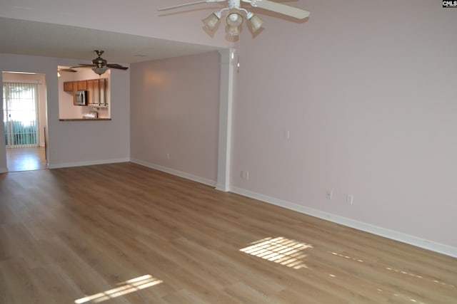 empty room with ceiling fan and light wood-type flooring