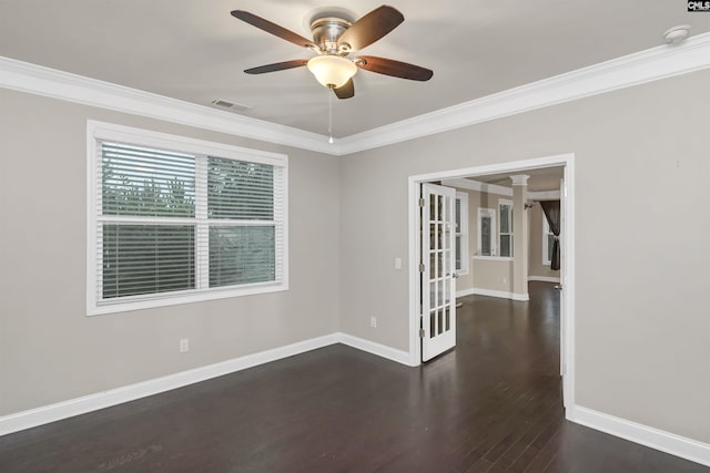 spare room featuring dark hardwood / wood-style flooring, decorative columns, ceiling fan, and crown molding