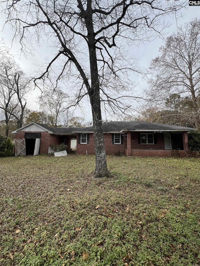 rear view of house featuring an outdoor structure and a lawn