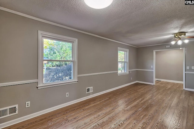 empty room with crown molding, ceiling fan, wood-type flooring, and a textured ceiling