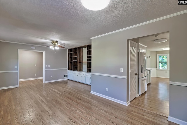 unfurnished living room with ceiling fan, ornamental molding, a textured ceiling, and light wood-type flooring