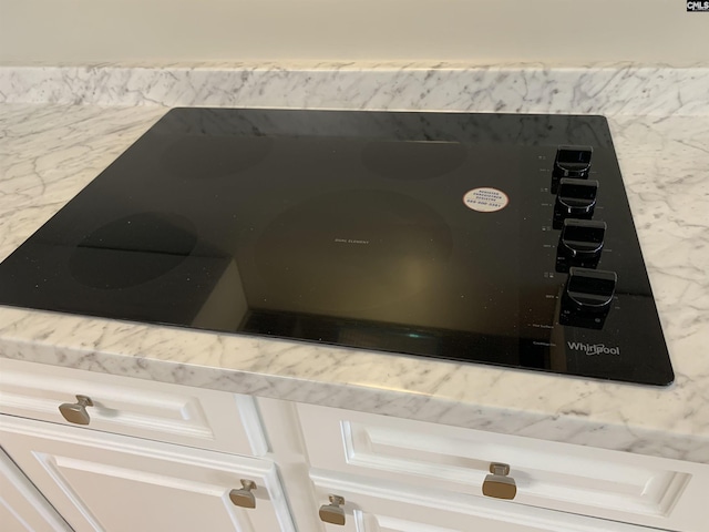 interior details featuring black electric cooktop and white cabinetry