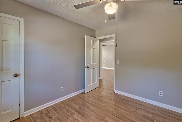 unfurnished bedroom featuring ceiling fan, light hardwood / wood-style floors, and a textured ceiling