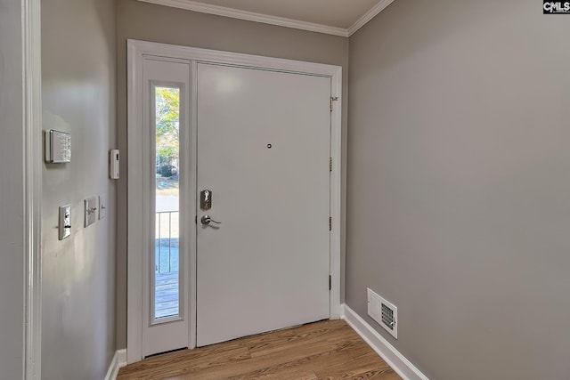 doorway to outside with light hardwood / wood-style flooring and crown molding