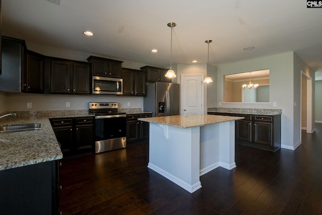 kitchen featuring dark hardwood / wood-style flooring, a kitchen island, sink, and stainless steel appliances