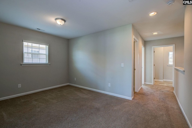 carpeted spare room featuring plenty of natural light