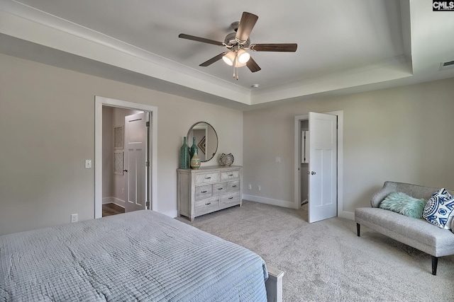 carpeted bedroom featuring a raised ceiling, ceiling fan, and ensuite bathroom