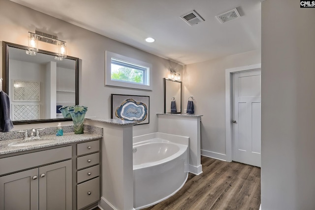 bathroom featuring hardwood / wood-style floors, vanity, and a tub