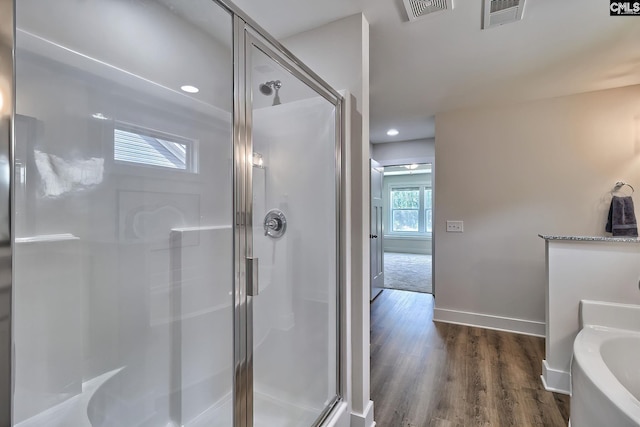 bathroom with hardwood / wood-style floors and separate shower and tub