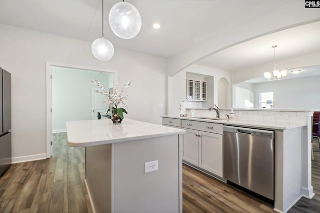 kitchen featuring dark hardwood / wood-style flooring, dishwasher, a kitchen island, and hanging light fixtures