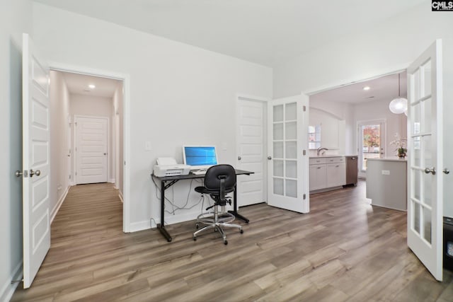 office featuring french doors, sink, and wood-type flooring