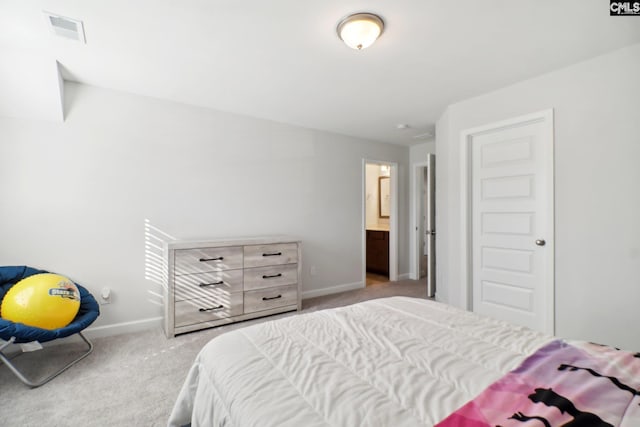 bedroom with connected bathroom and light carpet