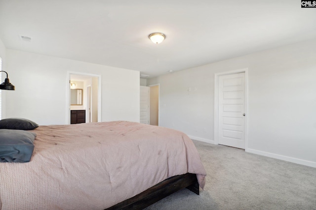 carpeted bedroom featuring ensuite bath